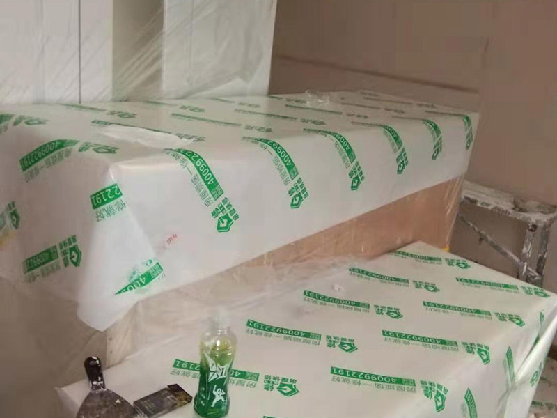 全屋家具成品保護(hù)：滿(mǎn)鋪成品瓦楞紙板，再用干凈彩條布滿(mǎn)鋪在普通石膏板上，在彩條布交接處及轉(zhuǎn)角處用膠帶固定，也可選用木芯板或三夾板。材料選用視上人、車(chē)情況而定。 所有成品飾面板在安裝好后必須用PE保護(hù)膜覆蓋包起來(lái)，所有成品飾面板的陽(yáng)角位必須用硬質(zhì)紙護(hù)角或泡沫棉進(jìn)行保護(hù)性包裝，防止交被其他施工人員碰撞。 1、入戶(hù)門(mén)扇用公司統(tǒng)一的門(mén)貼進(jìn)行全面包裹保護(hù)，用透明膠帶將保護(hù)膜粘貼牢固平整。 2、用標(biāo)準(zhǔn)保護(hù)膜將門(mén)框三面保護(hù)完整并固定牢固。 3、工程完工后拆除保護(hù)膜時(shí)如果有粘貼時(shí)的膠痕，應(yīng)用酒精或?qū)Ｓ玫那逦蹌┣宄z痕。