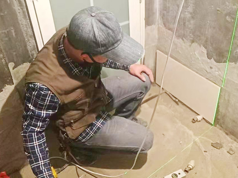 衛(wèi)生間墻面貼磚：施工前將需要的材料整齊堆放在一旁待用。首先應(yīng)除去基層表面的污垢，油漬，浮灰;除去基層上所有涂料層，膩?zhàn)訉?如果基層未能達(dá)到平整度要求，需對(duì)基層進(jìn)行預(yù)先的找平處理。 鋪貼瓷磚前需事先找好垂直線，以此為基準(zhǔn)鋪貼的瓷磚高低均勻、垂直美觀;此外，施工前在墻體四周需彈出標(biāo)高控制線，在地面彈出十字線，以控制地磚分隔尺寸。 加水后將粘結(jié)劑漿料攪拌至潤(rùn)滑均勻，無明顯塊狀或糊狀結(jié)塊，攪拌后的漿料靜置5-10分鐘后再稍加攪拌1-2分鐘即可使用。在開始鋪貼施工前，需要先清理瓷磚表面的浮灰，污垢等。將調(diào)制好的漿料均勻地抹在瓷磚背面，要求漿料飽滿。將瓷磚平整地鋪貼在基層上，使用橡膠錘將瓷磚拍實(shí)鋪平。施工過程中，可小幅度轉(zhuǎn)動(dòng)瓷磚，使?jié){料與瓷磚背面充分接觸。