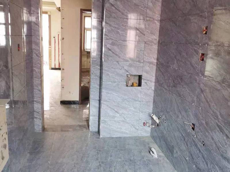 全屋瓷磚鋪貼：首先應除去基層表面的污垢，油漬，浮灰;除去基層上所有涂料層，膩子層;如果基層未能達到平整度要求，需對基層進行預先的找平處理。鋪貼瓷磚前需事先找好垂直線，以此為基準鋪貼的瓷磚高低均勻、垂直美觀;此外，施工前在墻體四周需彈出標高控制線，在地面彈出十字線，以控制地磚分隔尺寸。加水后將粘結(jié)劑漿料攪拌至潤滑均勻，無明顯塊狀或糊狀結(jié)塊，攪拌后的漿料靜置5-10分鐘后再稍加攪拌1-2分鐘即可使用。將瓷磚平整地鋪貼在基層上，使用橡膠錘將瓷磚拍實鋪平。施工過程中，可小幅度轉(zhuǎn)動瓷磚，使?jié){料與瓷磚背面充分接觸。